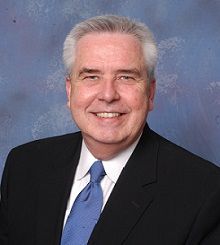 A man in a suit and tie is smiling for the camera.