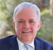 A man in a suit and tie is smiling for the camera.