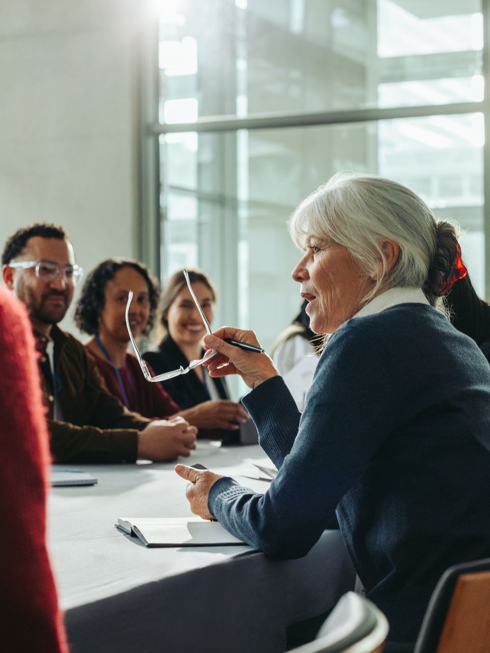 A group of people are sitting around a table having a meeting.