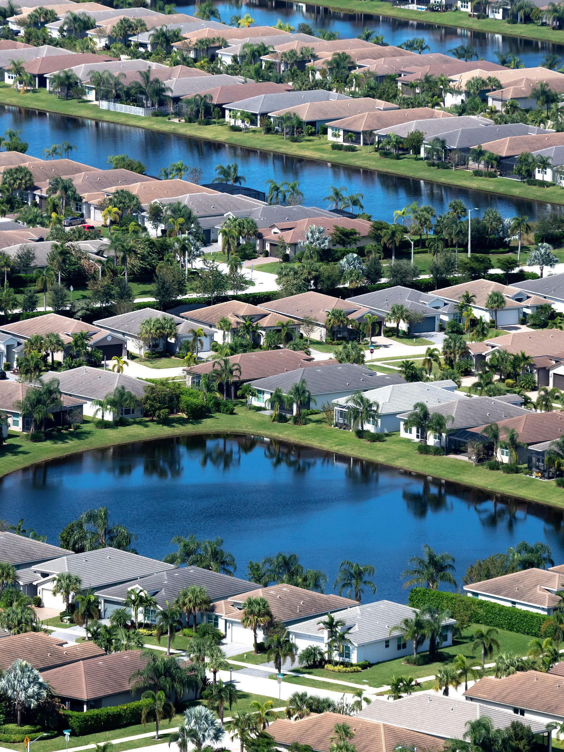 An aerial view of a residential area with lots of houses and ponds.
