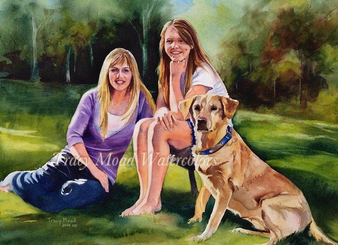 Two women and a yellow lab dog sitting on grass in a park, smiling.