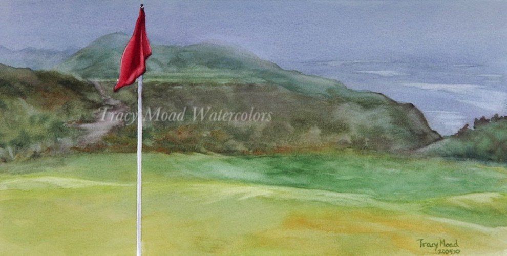 Red flag on a golf course overlooking green hills and water under an overcast sky.