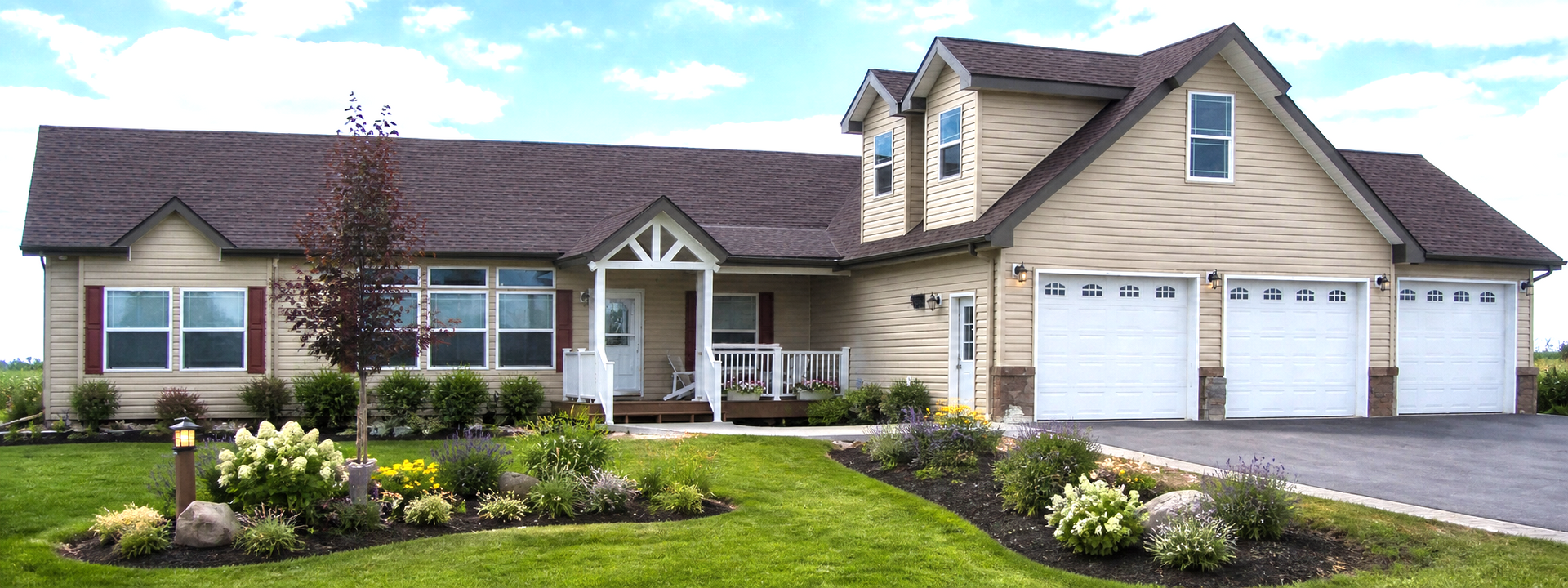 Single-story suburban house with beige siding, brown roof, double garage, and landscaped front yard