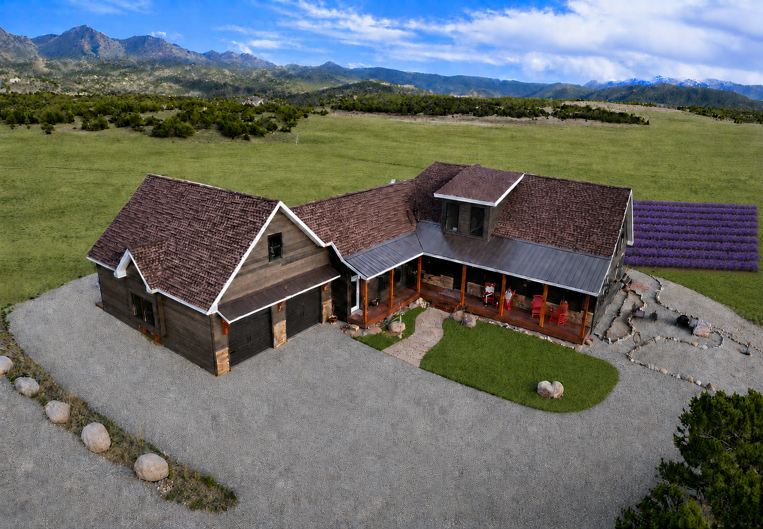 Aerial view of a rustic house with gravel driveway, red roof, and mountain backdrop under a blue sky
