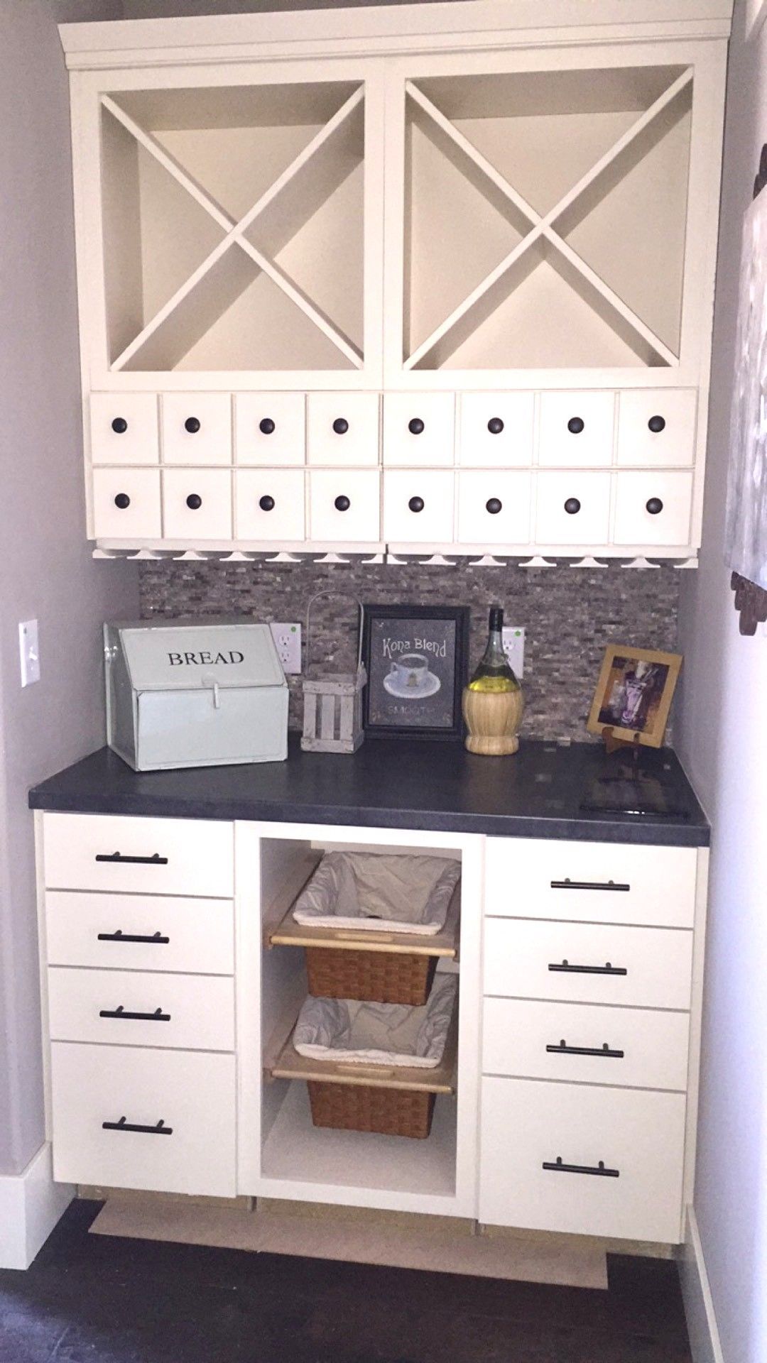 White home office cabinet with drawers, cubbies, baskets, and decor under matching wall storage boxes.
