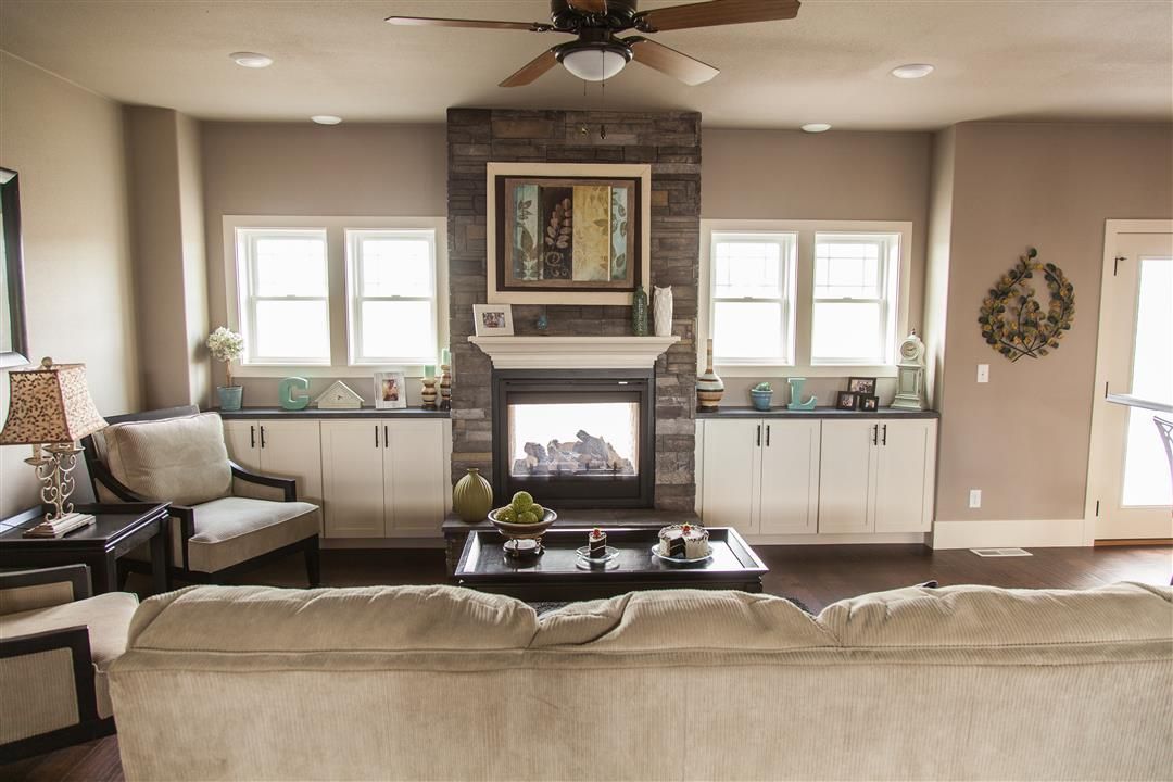 Bright living room with a fireplace, sofa, windows, and neutral decor