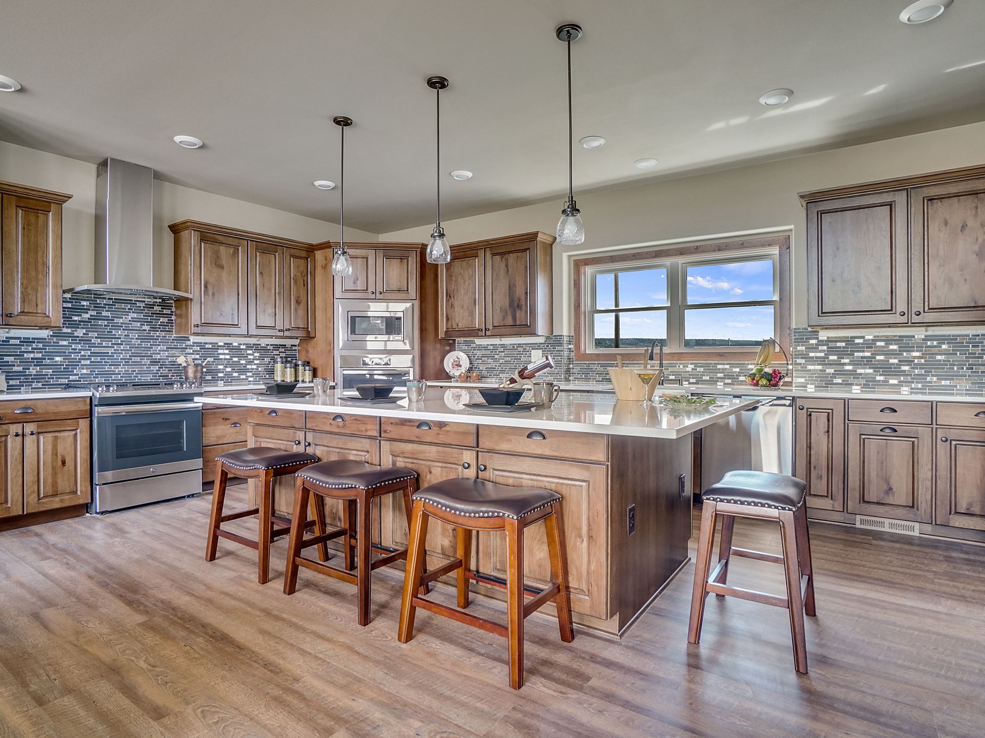 Modern kitchen with wood cabinets, island seating, and stainless steel appliances