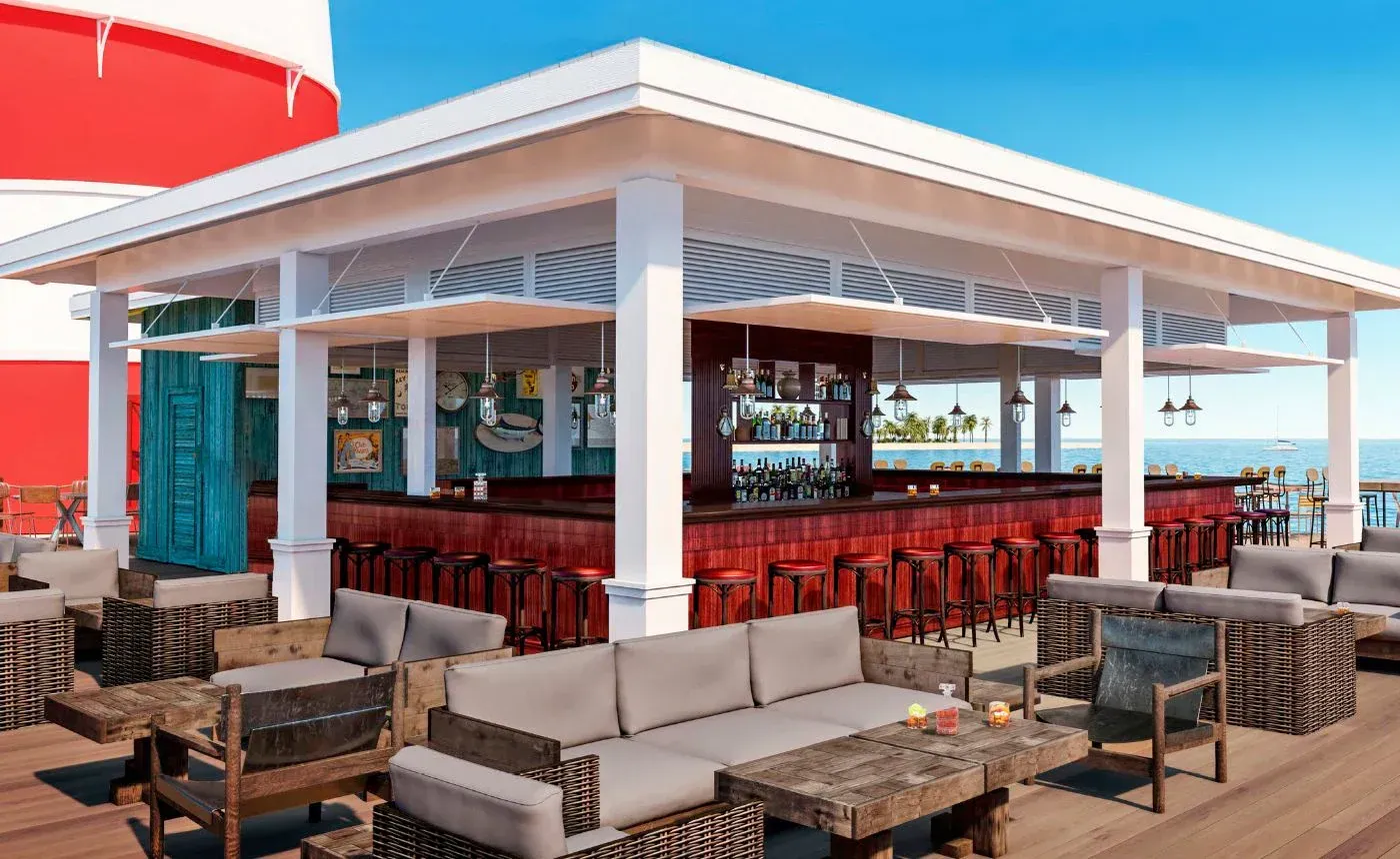 Outdoor bar with red stools, wood counter, and ocean view, near a red and white lighthouse.