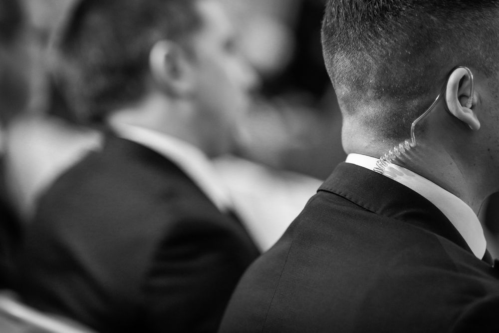 A black and white photo of a man wearing a suit and tie