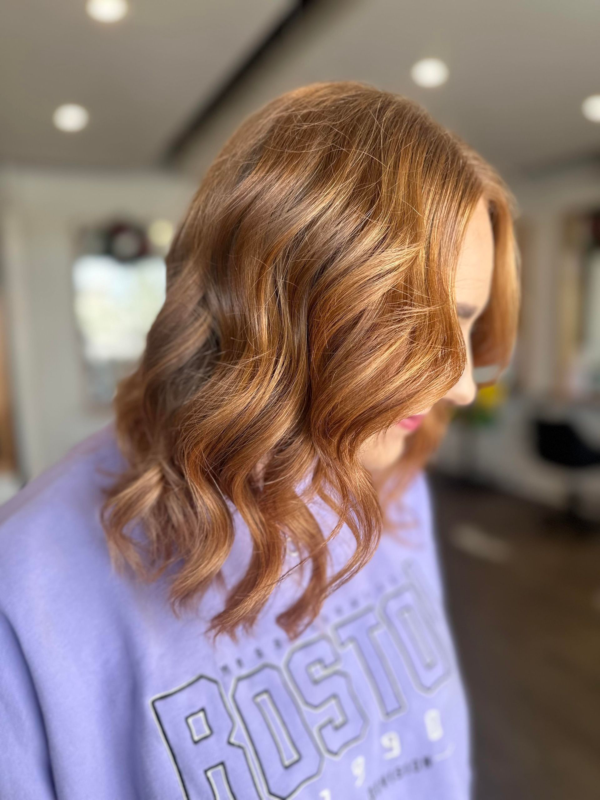 A Woman Is Wearing A Purple Sweatshirt With The Word Rosto On It — Arabella Hair Design in Sebastopol, VIC
