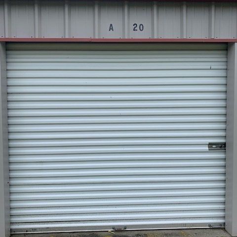 Closed white roll-up storage door with a small lock, labeled “A 20” above it.