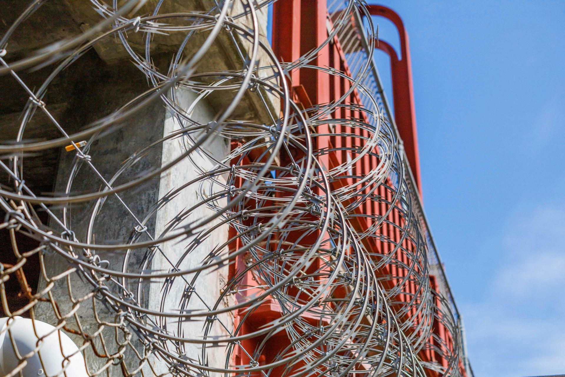 A close up of a chain link fence with trees in the background.