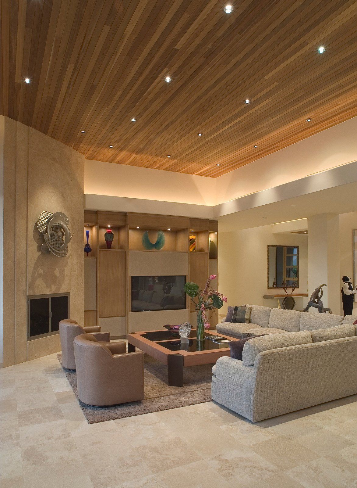 Living room with wood ceiling, fireplace, neutral-toned furnishings, and recessed lighting.