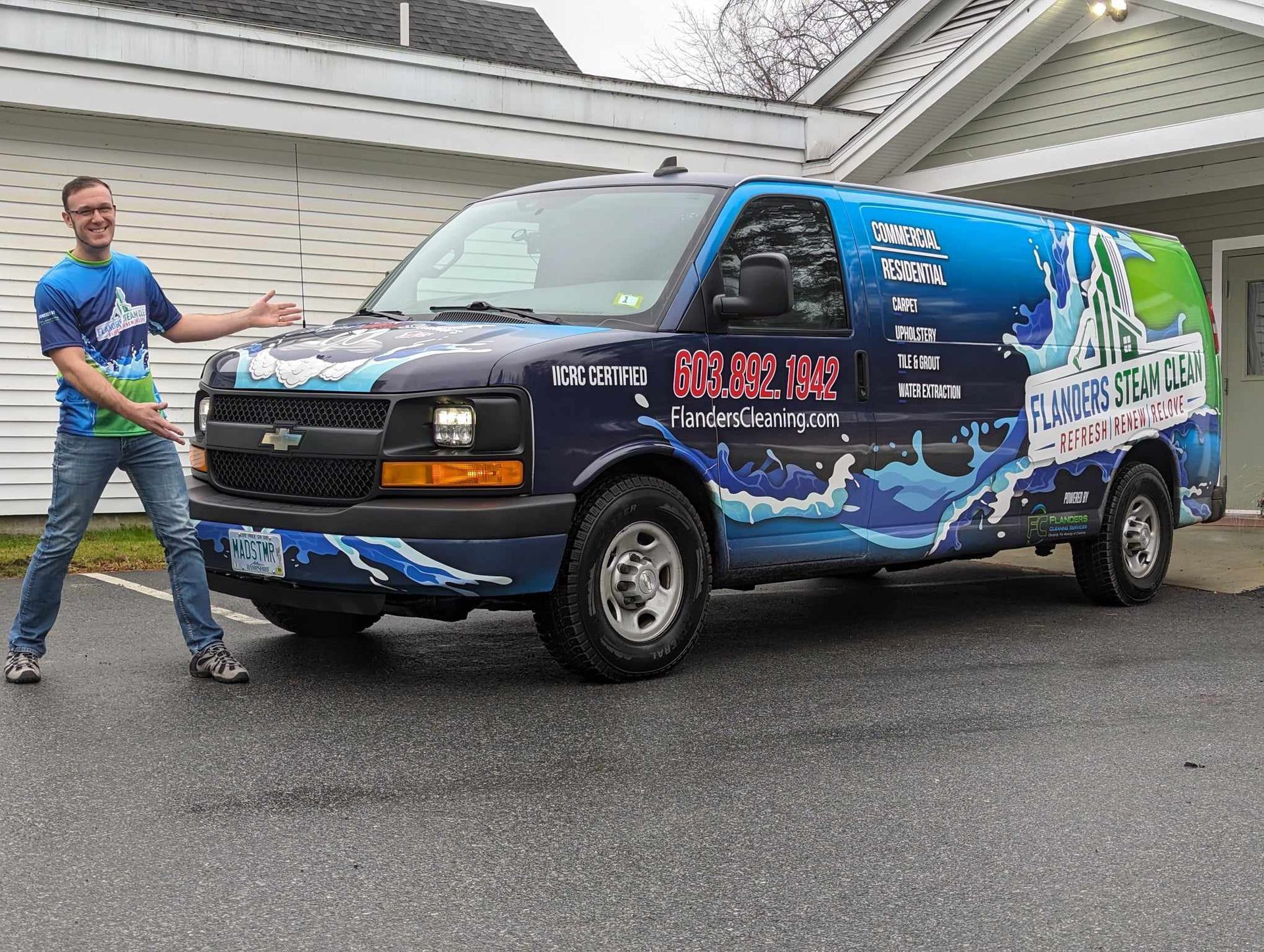 A man is standing next to a blue and green van.