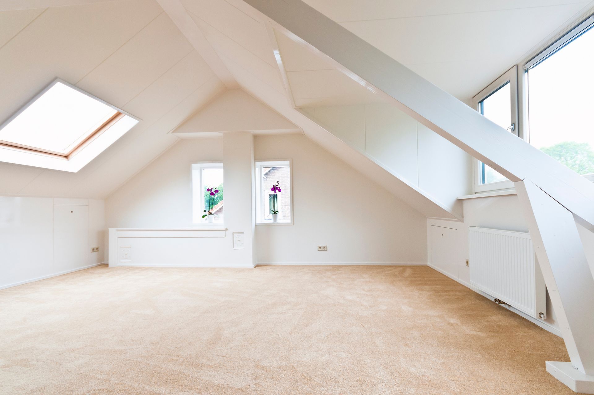 An empty attic with a skylight in the ceiling