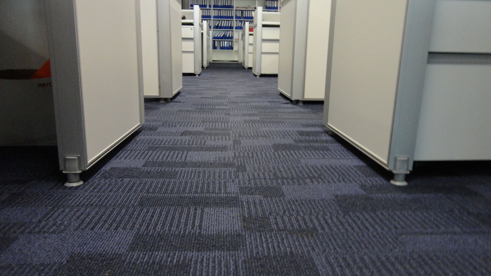 Office hallway with gray carpet and white cubicle partitions