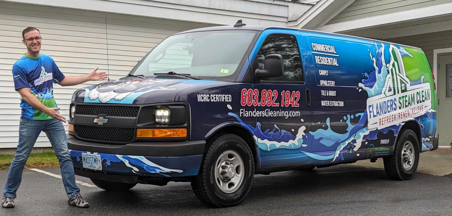 A man is standing next to a blue van.