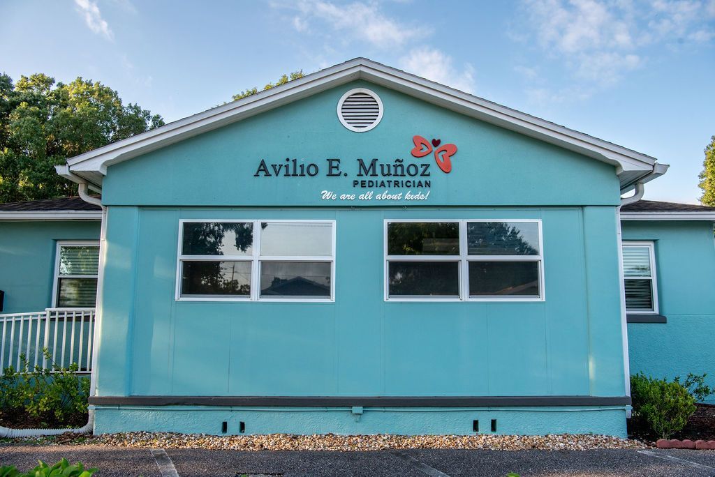 A blue building with the name Avilio E. Munoz Pediatrics on it.
