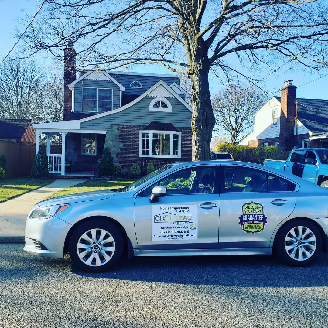 Silver sedan with campaign signs parked in front of a house on a sunny street
