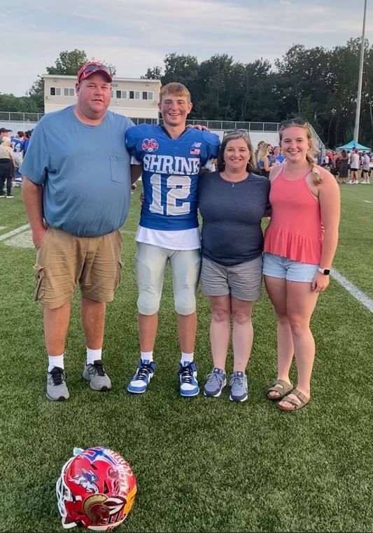 A group of people are posing for a picture on a football field.