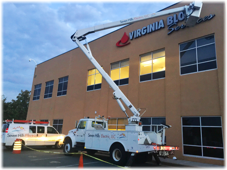 white bucket truck working on a building sign white bucket truck working on a building sign