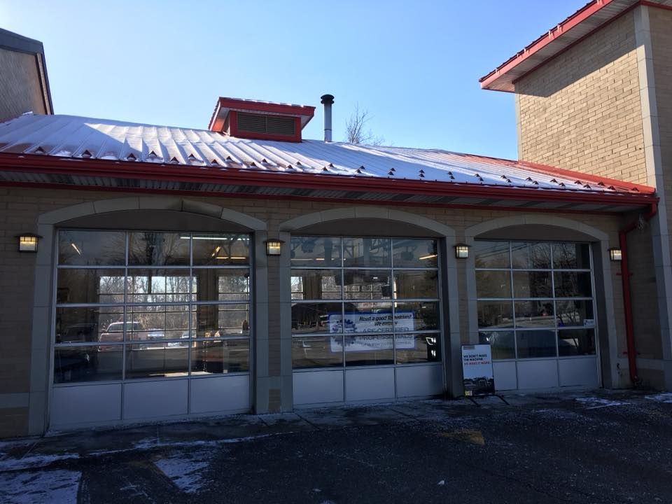 Small storefront with large windows and a red roof in bright daylight