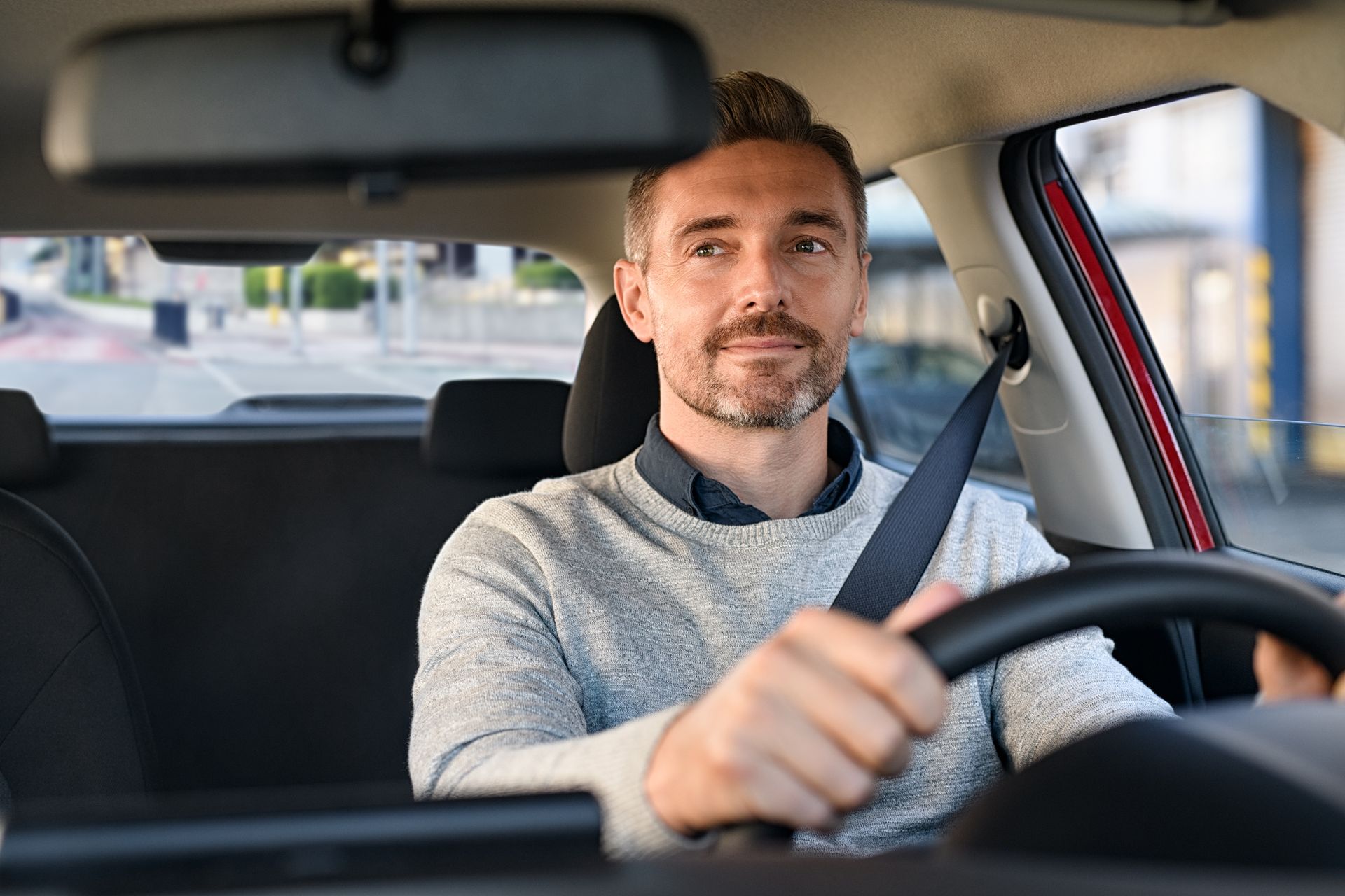 A man is sitting in the driver 's seat of a car. | Taggart's Driving School | Tucker, Georgia A man is sitting in the driver 's seat of a car.