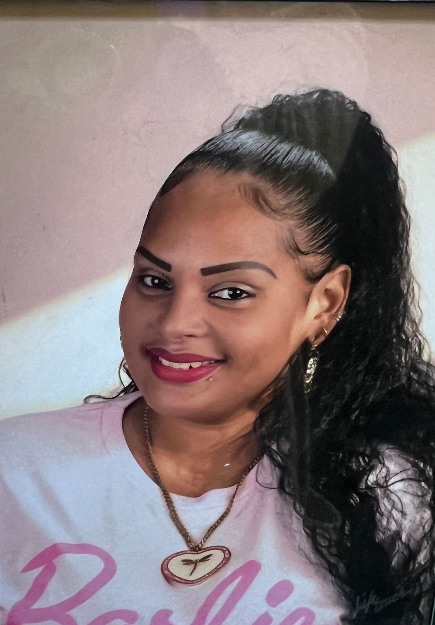 A woman wearing a pink barbie shirt is smiling