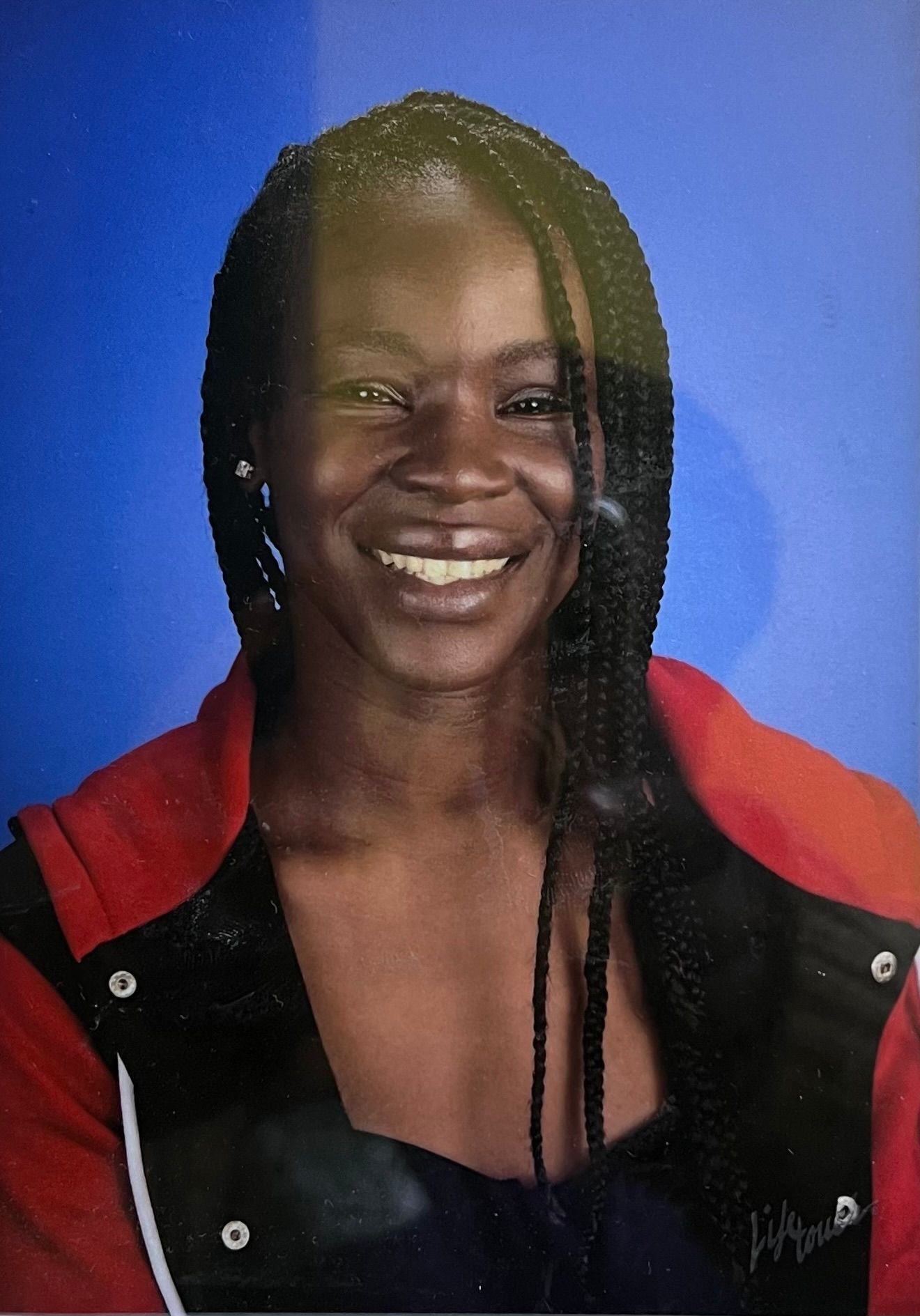A woman in a red jacket is smiling for the camera