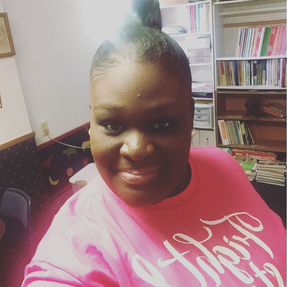 A woman wearing a pink shirt that says