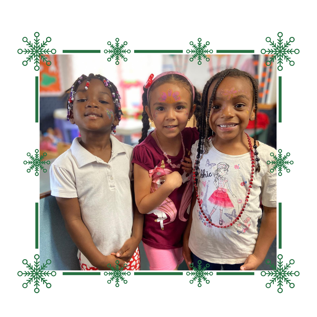 Three little girls are posing for a picture in a frame with snowflakes.