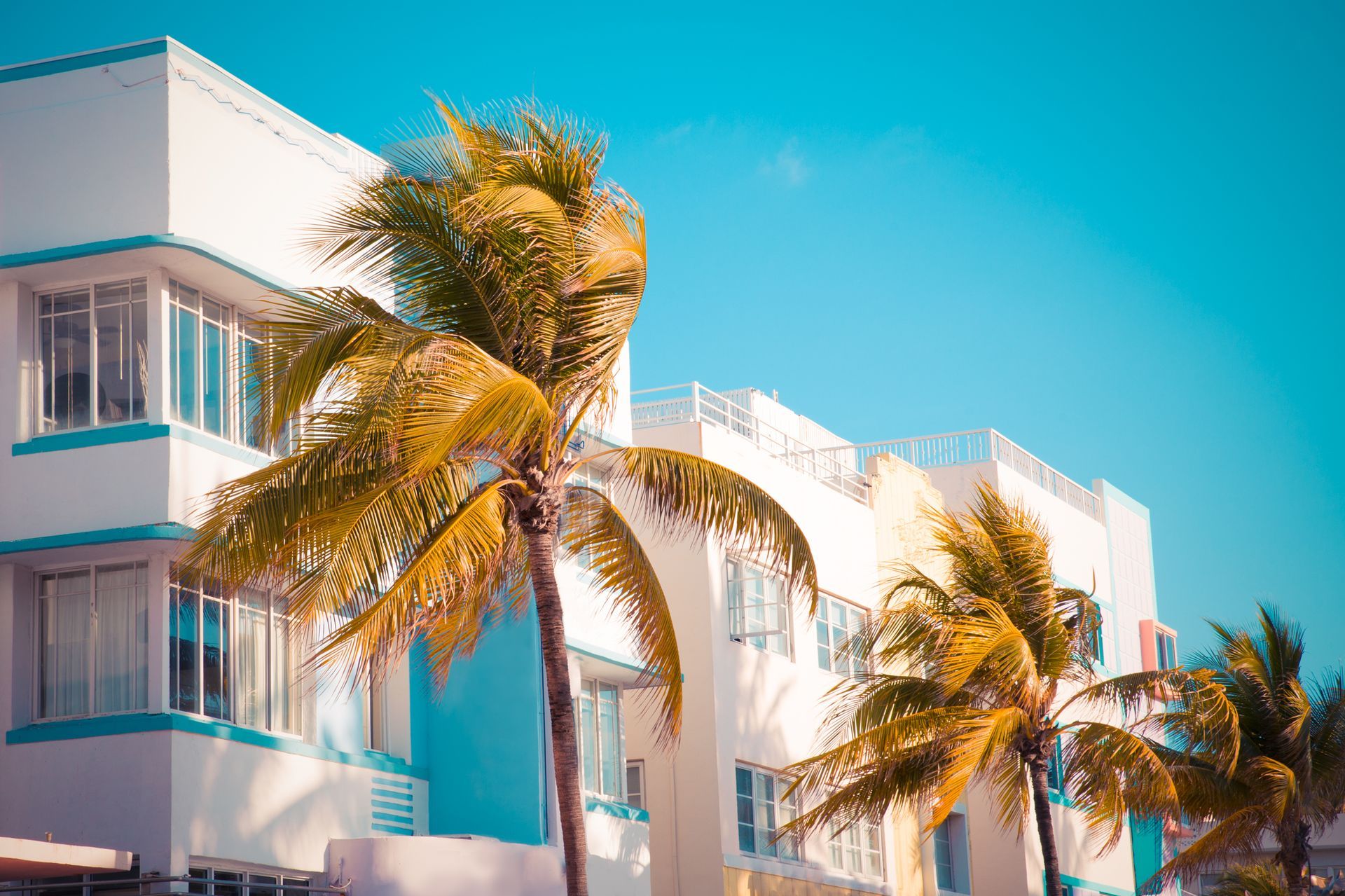 A large apartment building with a lot of windows and balconies against a blue sky.