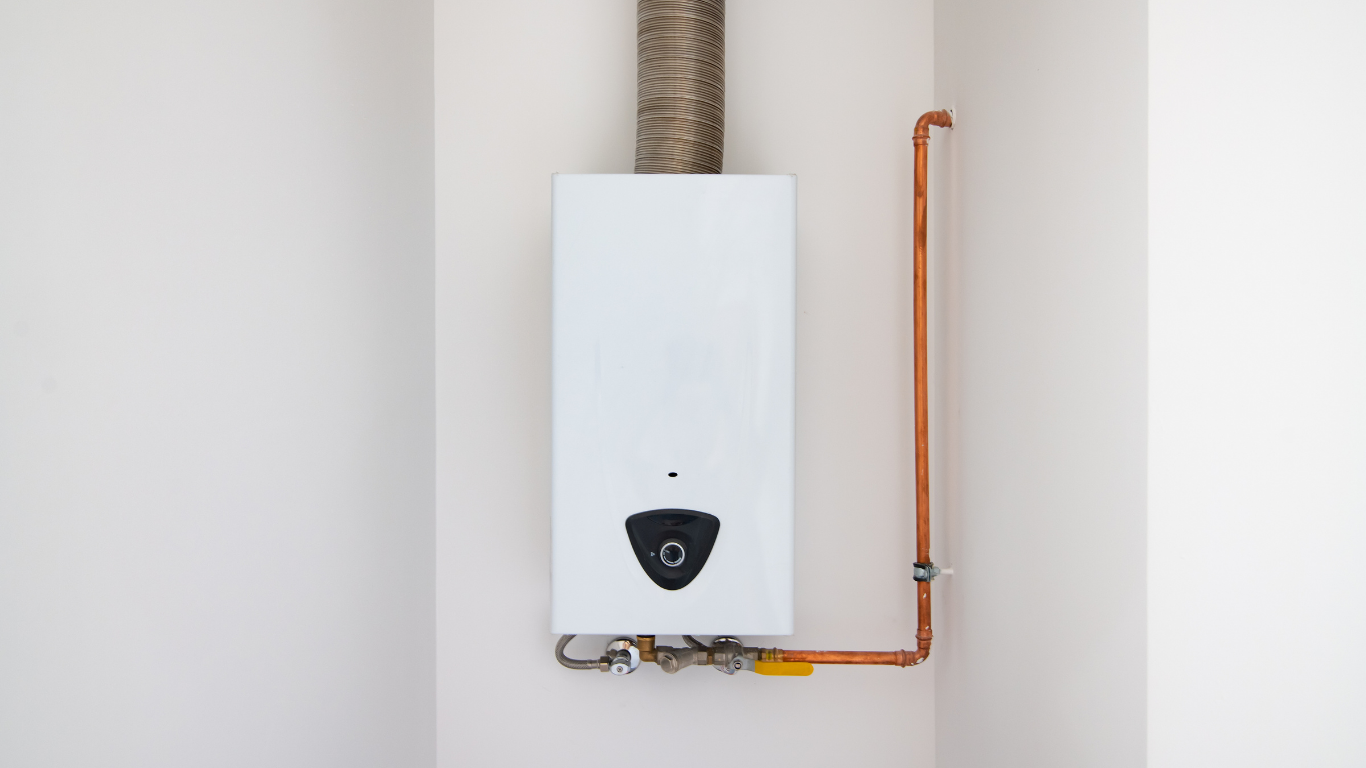 White wall-mounted water heater with copper pipes and a vent pipe in a corner.
