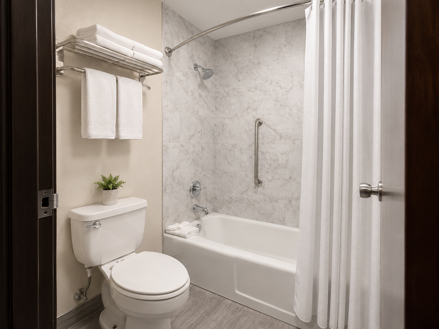 Small bathroom with white tub, toilet, sink, towel rack, and shower curtain.