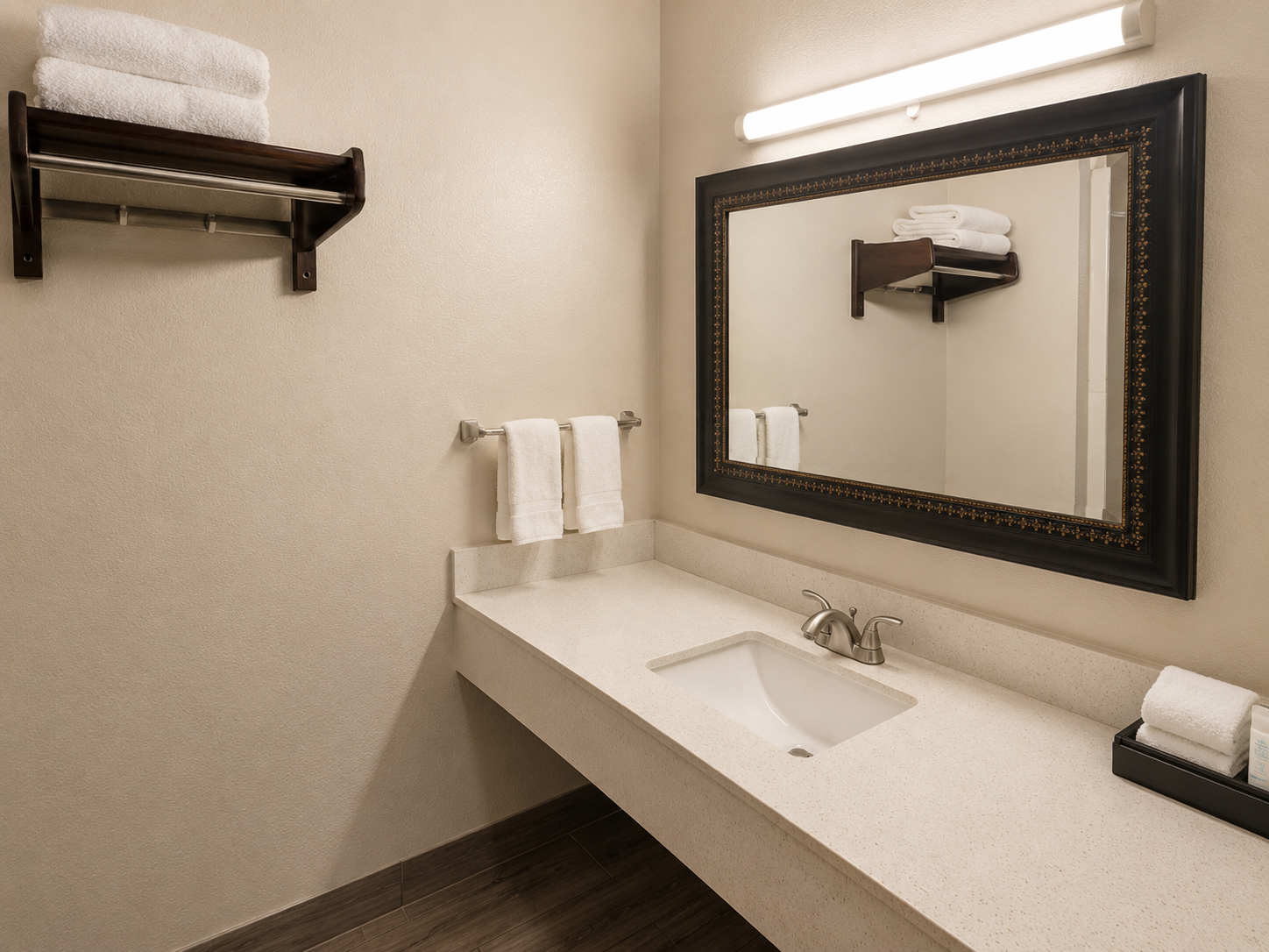 Accessible bathroom vanity with mirror, sink, towel rack, and toiletries on a white counter