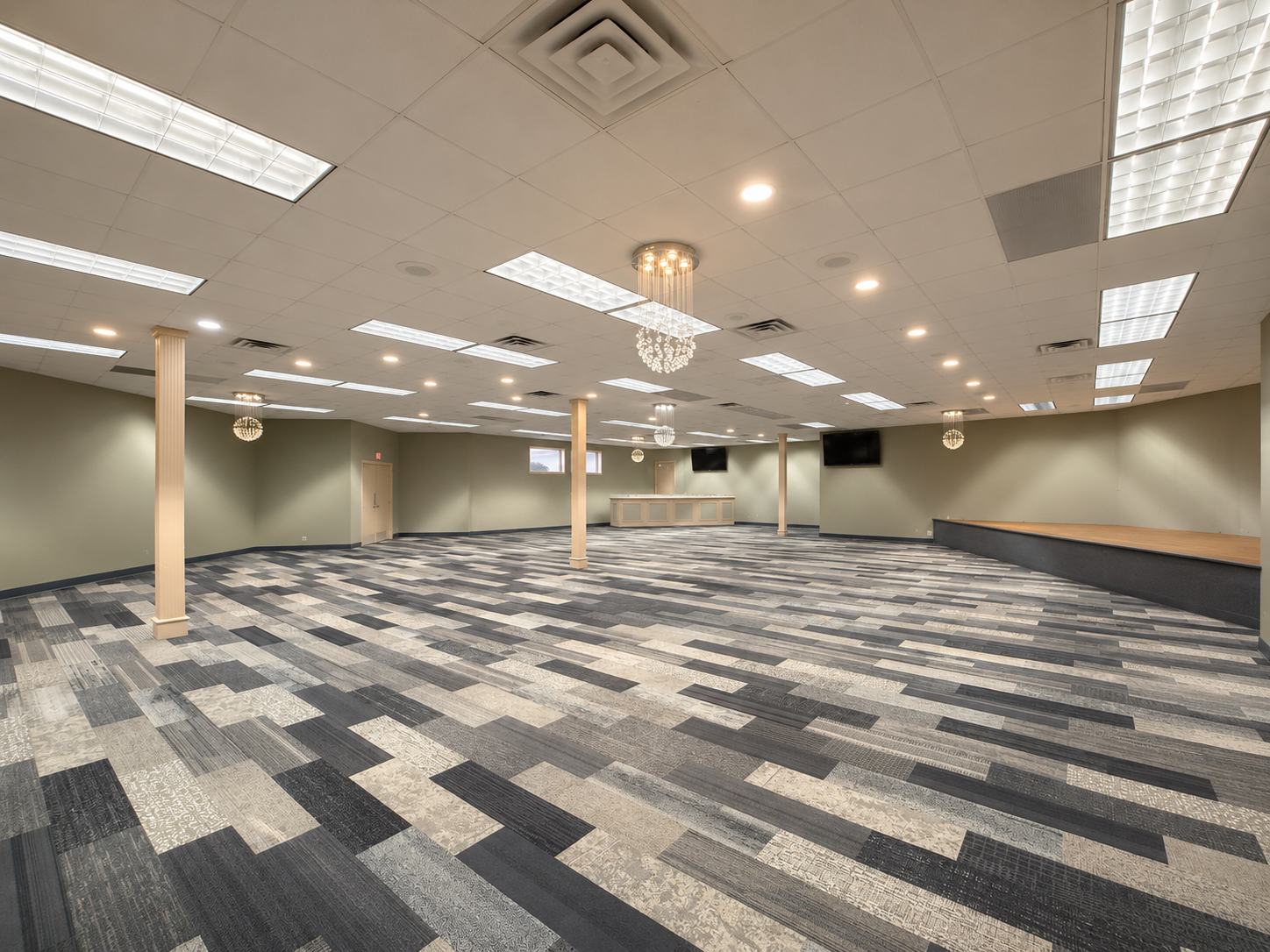 Empty carpeted conference room with fluorescent ceiling lights and beige walls
