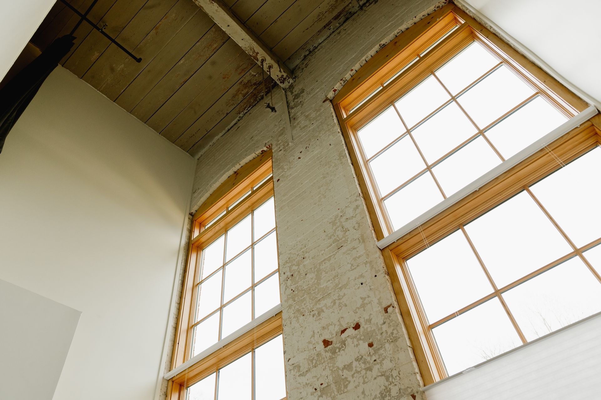 Large panoramic glass windows on exposed brick wall