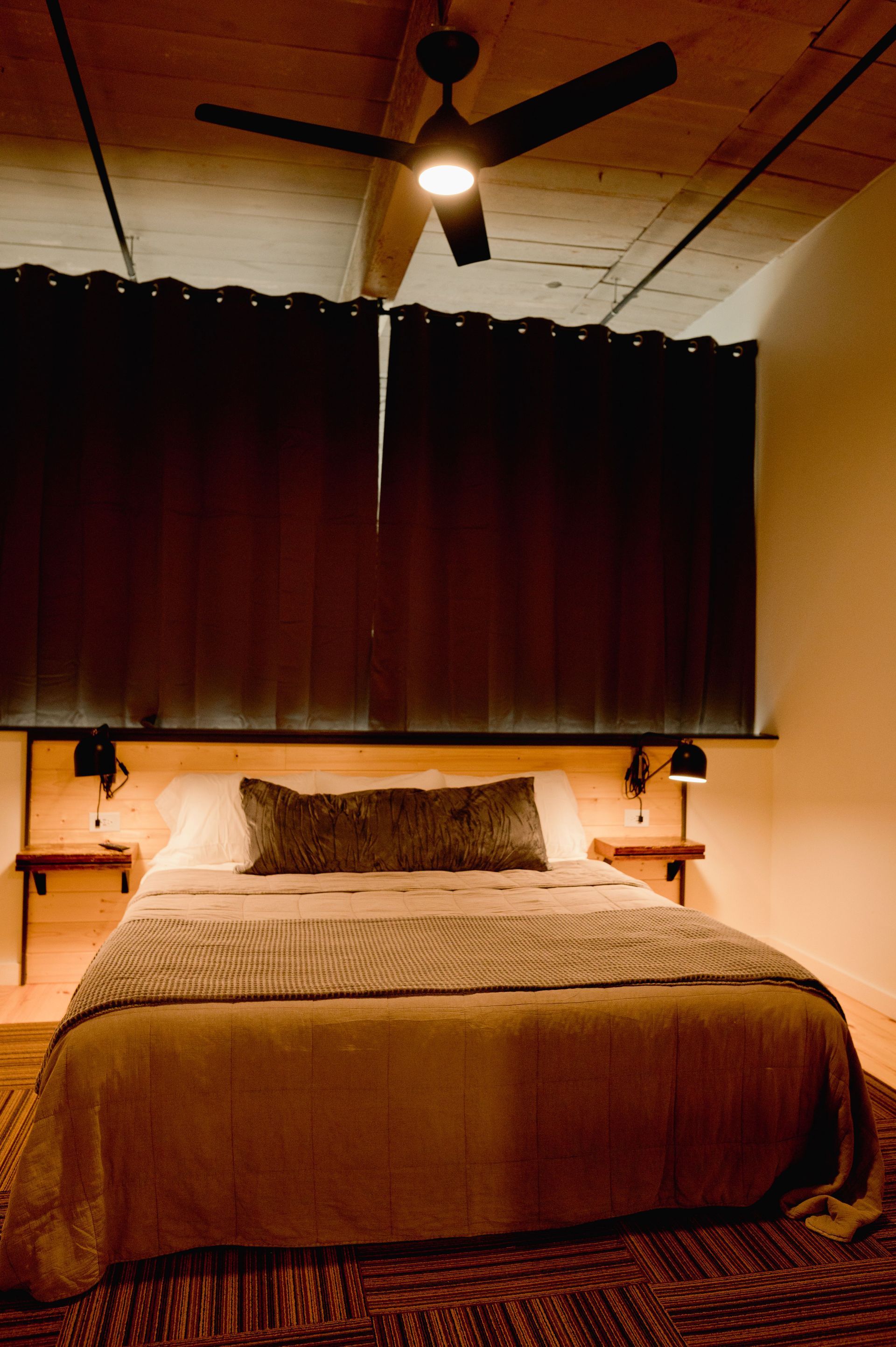 Closed black out curtains for deep sleep in dark boutique hotel bedroom