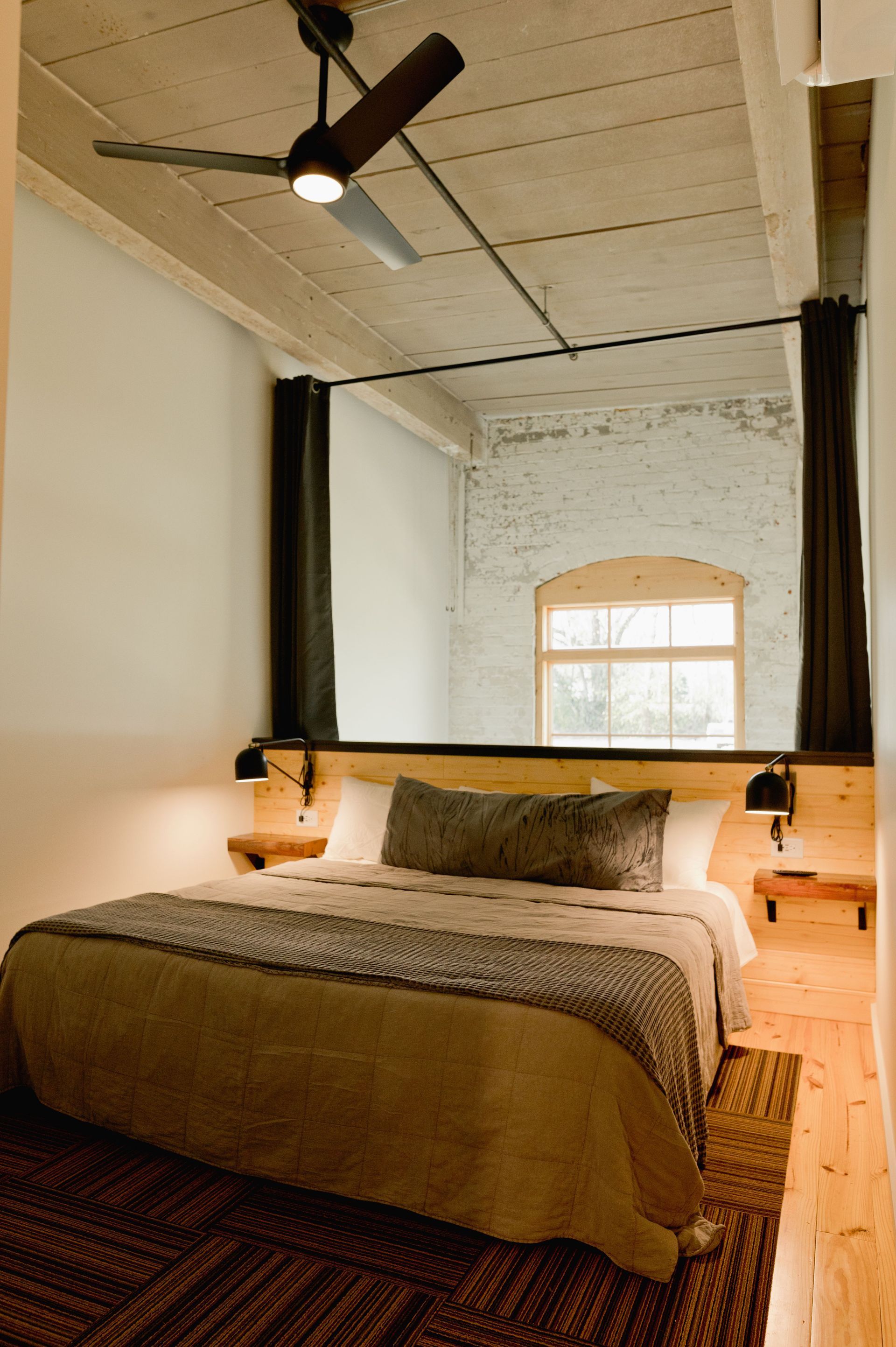King size bed with fan in loft open to below