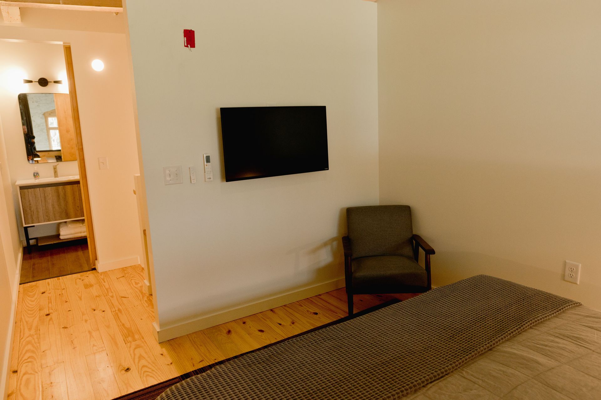 TV amenity across from bed for late night television with hardwood flooring