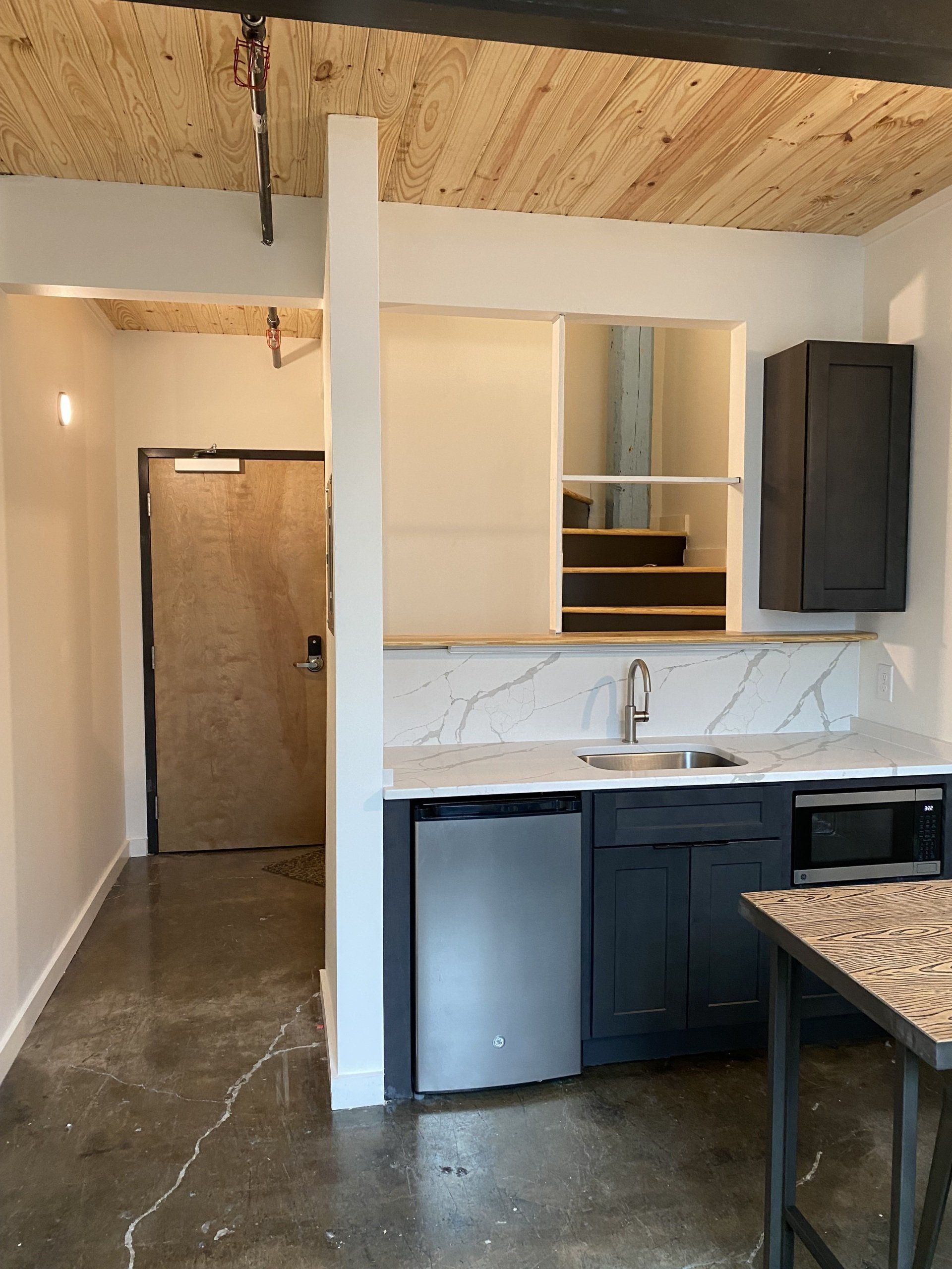 Boutique hotel room kitchenette with marble countertops and new appliances