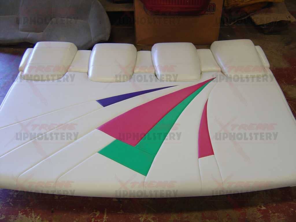 White upholstered cushion with colorful geometric triangle patterns on a sofa.