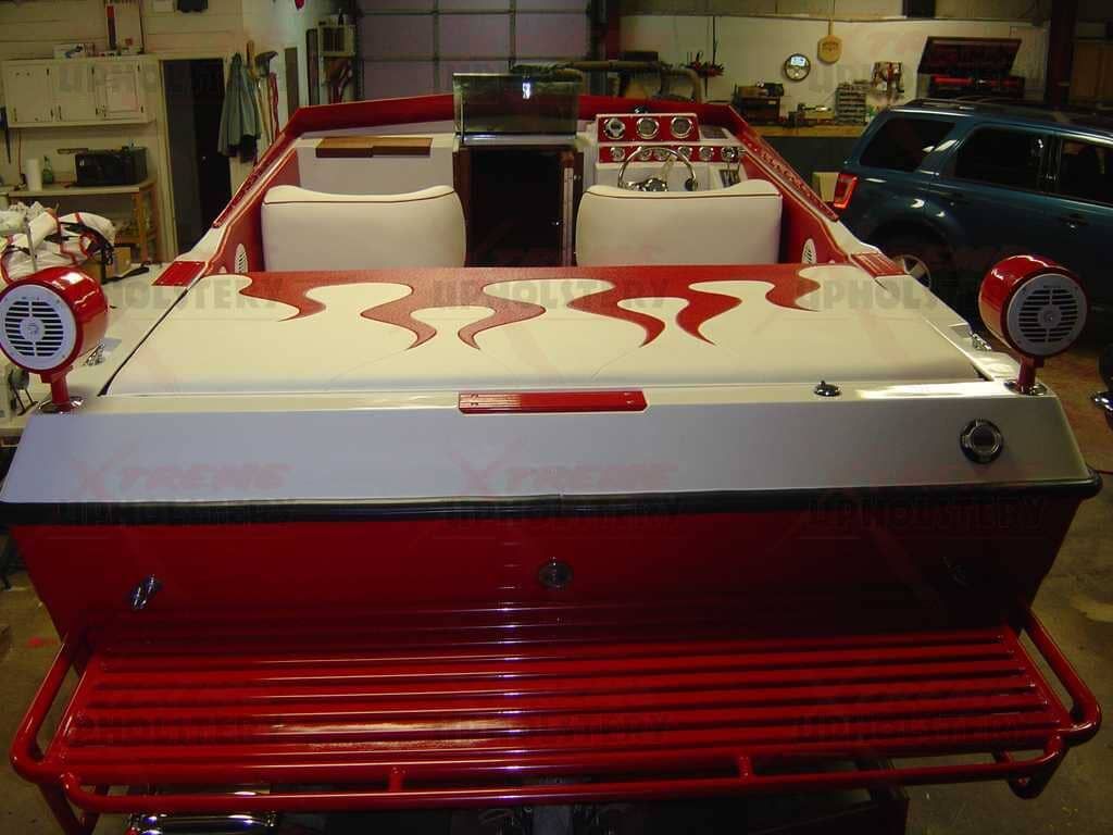 Red and white classic pickup truck in a garage, front view with flame decals on the hood.