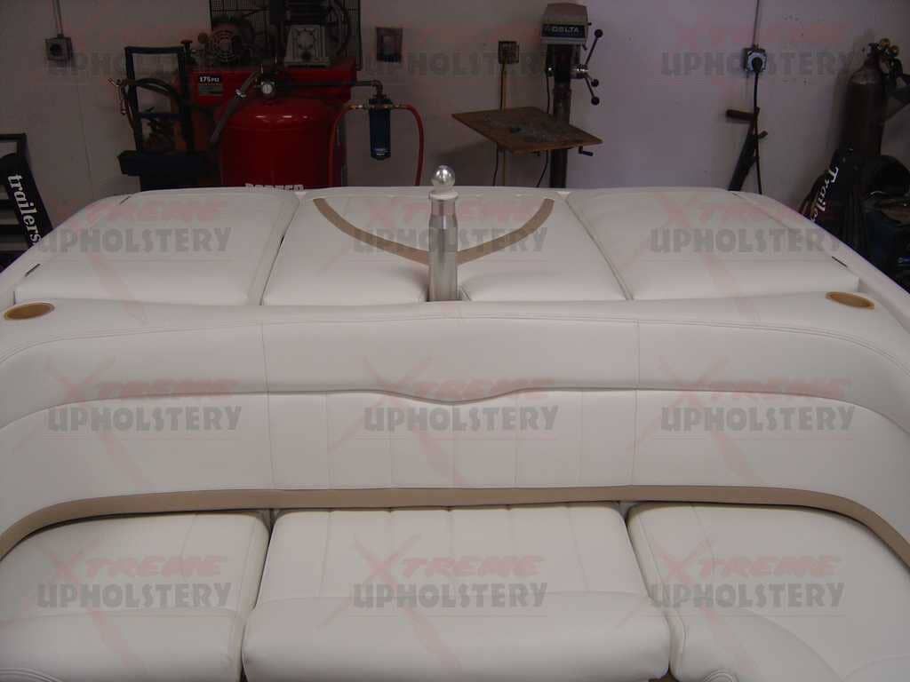 White upholstered furniture pieces in a showroom, with a central handle on the top panel.