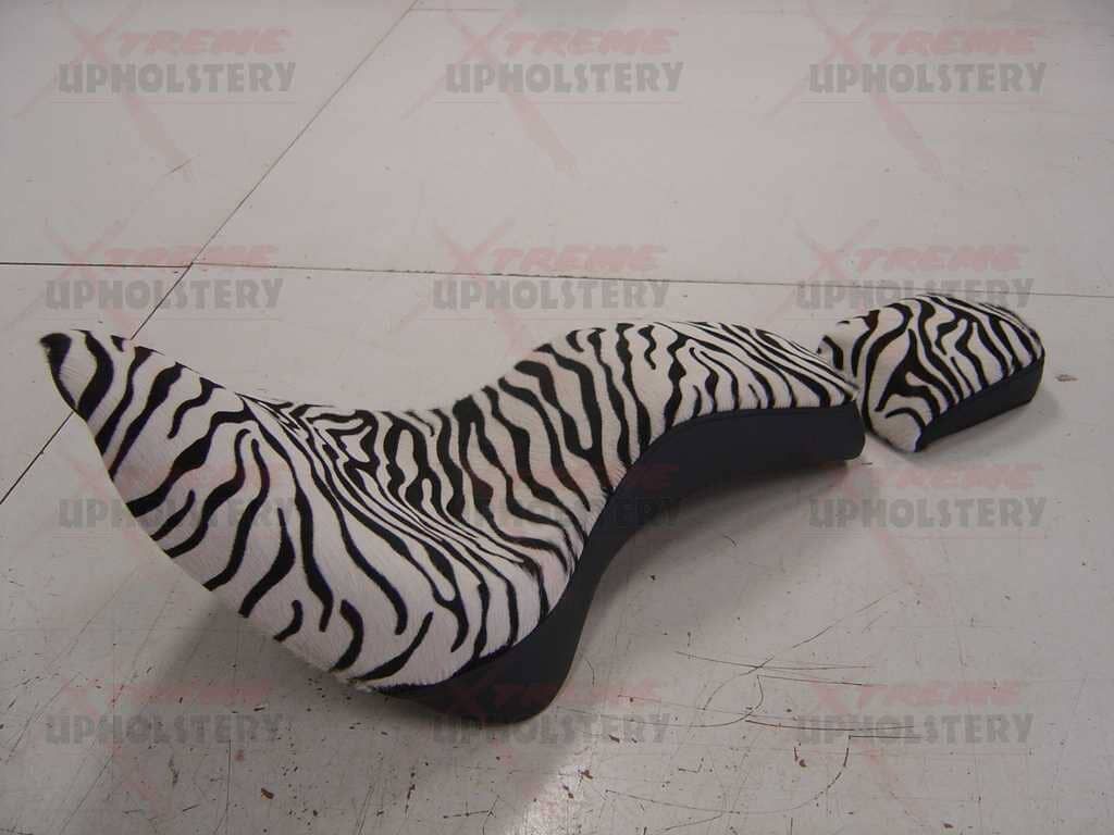 Black-and-white zebra-print upholstered chaise lounge on a light tiled floor
