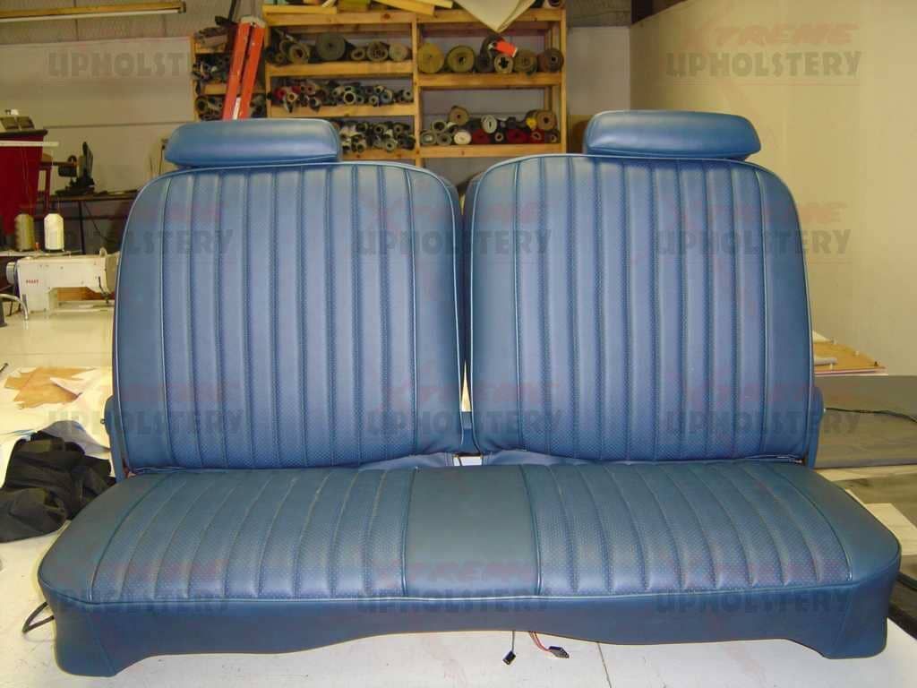 Blue vinyl car seat bench with two tall backrests in an upholstery shop