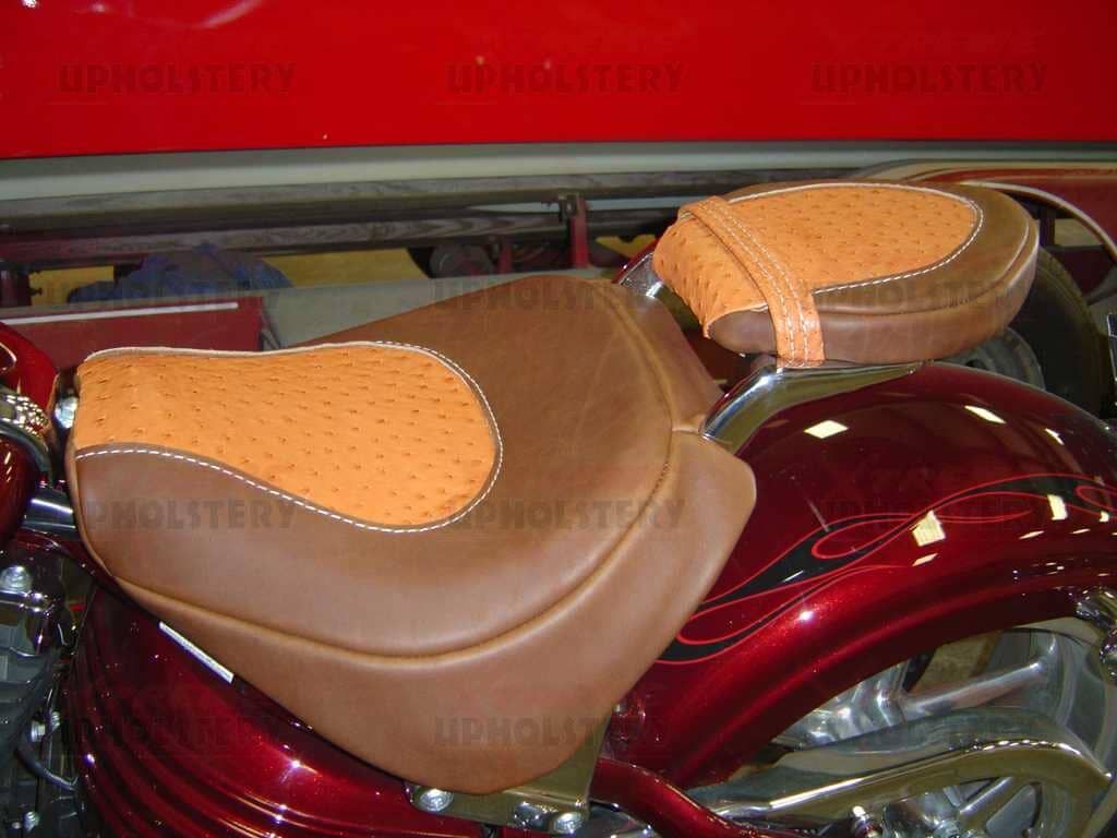 Brown and tan motorcycle seat on a glossy red bike in a showroom