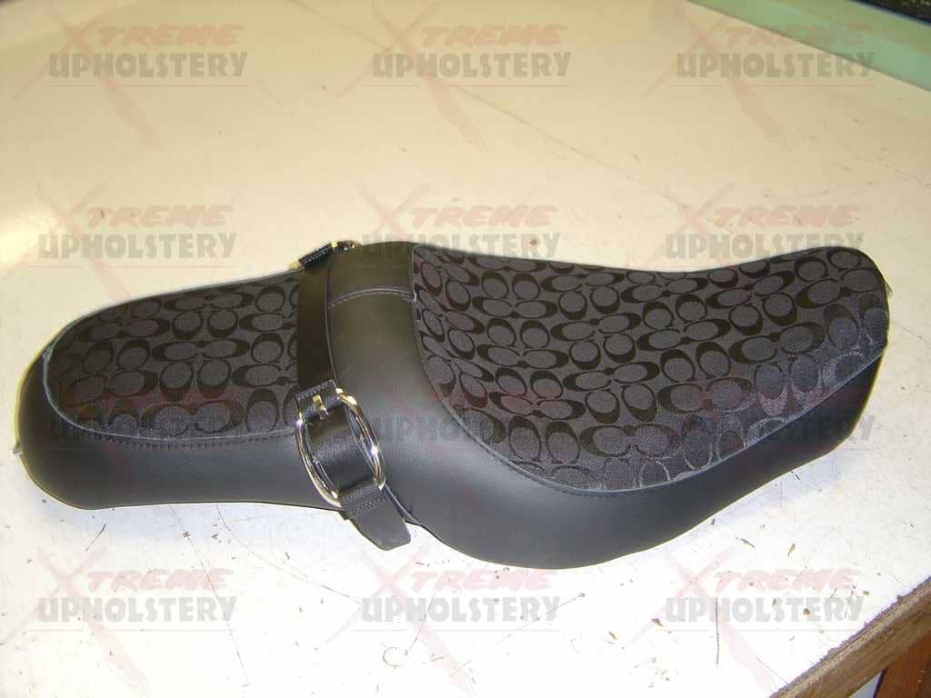 Black patterned women’s dress shoe with a strap, shown on a light background