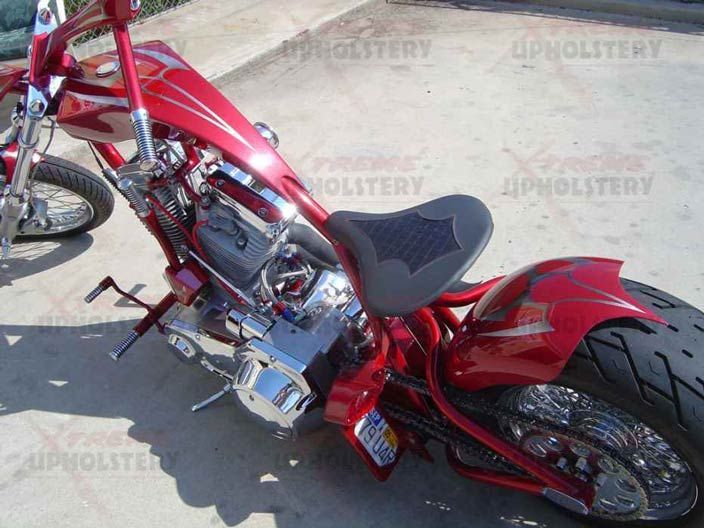 Red custom chopper motorcycle with chrome engine and red body parked on pavement