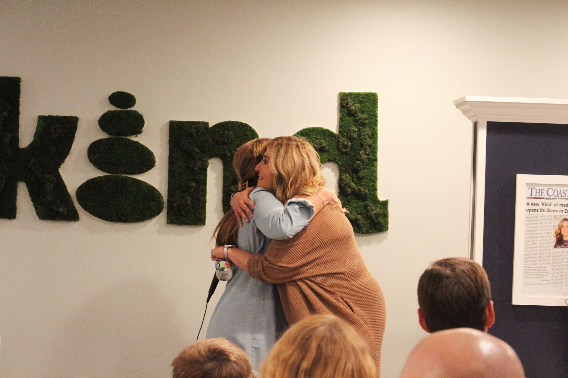 Two people embrace beneath a moss-covered 